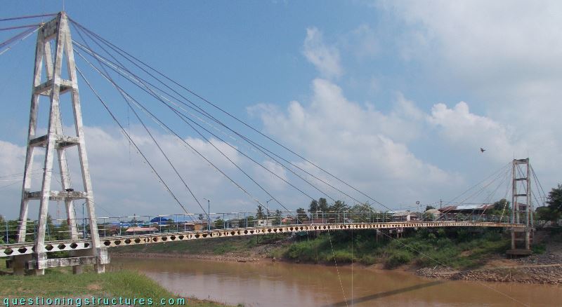 Cable-stayed bridge with castellated beams over a river.
