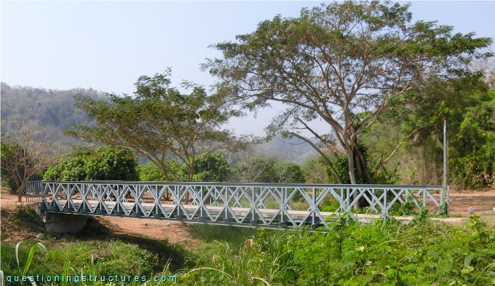 Pony truss bridge over a creek.