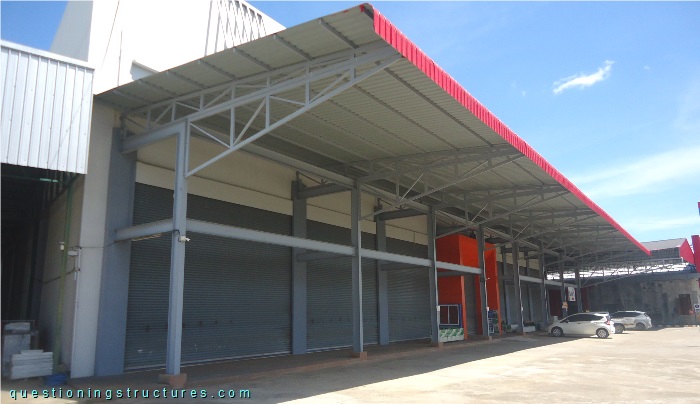 Industrial steel canopy roof with stacked trusses.
